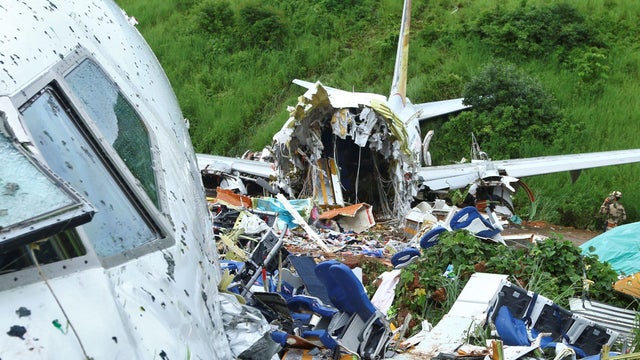 A security official inspects the site where a passenger plane crashed when it overshot the runway at the Calicut International Airport in Karipur