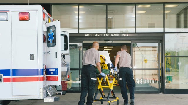 Paramedics taking patient on stretcher from ambulance to hospital