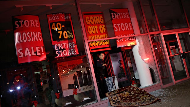 A police officer investigates inside a store that was looted in Philadelphia, Pennsylvania