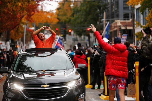 Nadine Gibson gestures from a car after the media announced that Democratic U.S. presidential nominee Joe Biden has won the 2020 U.S. presidential election, in Seattle 