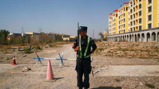 FILE PHOTO: A Chinese police officer takes his position by the road near what is officially called a vocational education centre in Yining 