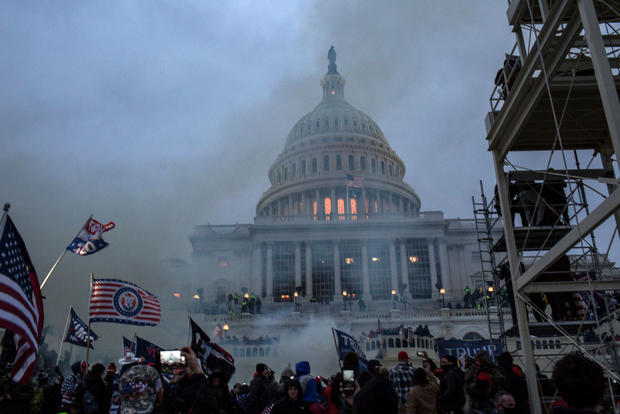 Security forces respond with tear gas after the US President 
