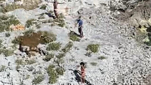 An aerial photo shows three people stranded on Anguilla Cay, Bahamas, February 8, 2021. 