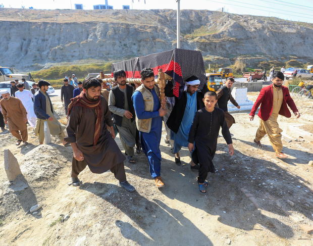 Afghan men carry the coffin of one of three female media workers who were shot and killed by unknown gunmen, in Jalalabad 