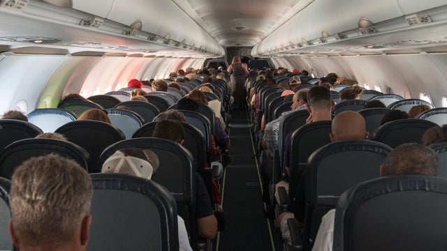 Rear View Of People Sitting In Airplane 