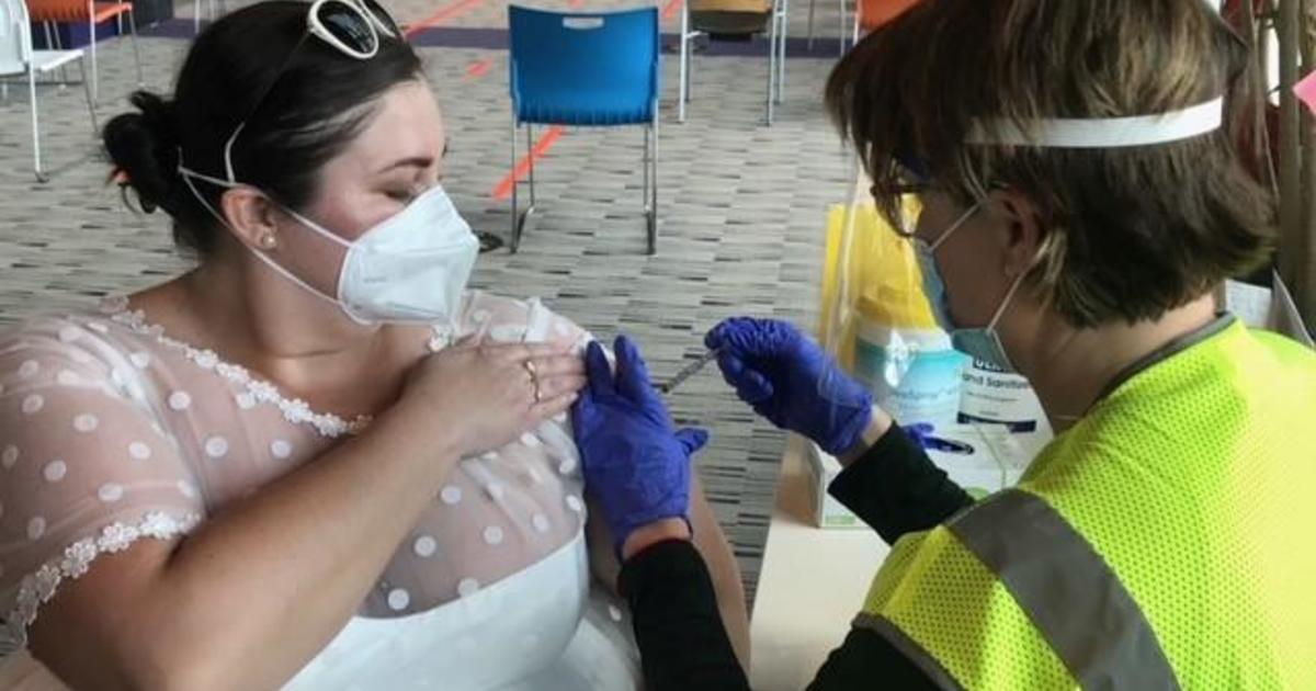 This bride's reception got canceled because of the pandemic — so she put on her wedding dress to get the COVID vaccine