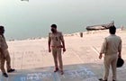 This frame grab from video provided by KK Productions shows police officials stand guard at the banks of the Ganges River, where several bodies were found, in Ghazipur district in Uttar Pradesh state, India, May 11, 2021. 