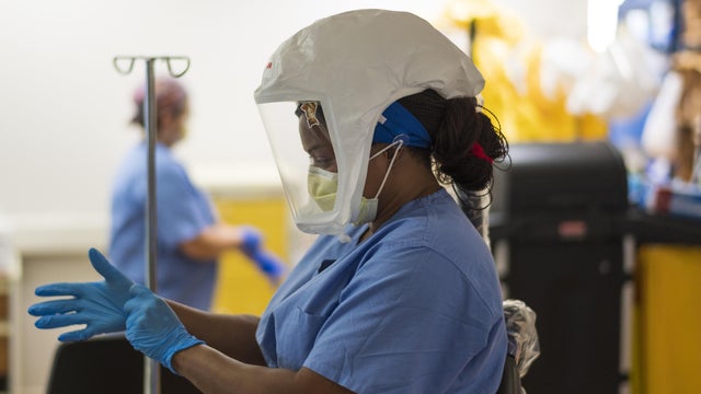Female doctor checking on Covid-19 infected patient while connected to a ventilator 