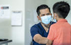 Young boy at a doctors appointment wearing a mask. 