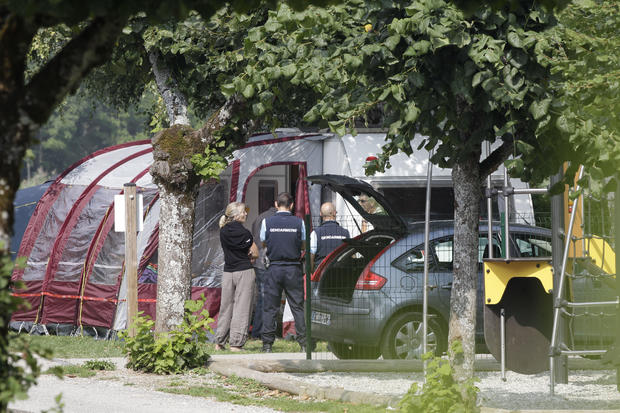 Gendarmes and investigators stand at the campsite where a slain British family were staying on holiday in Saint Jorioz, near Annecy, on September 6, 2012. 