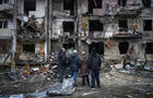 People look at the damage following a rocket attack on Kyiv, Ukraine, Feb. 25, 2022. 