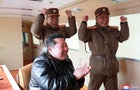 North Korean leader Kim Jong Un reacts next to military officials during what state media reports is the launch of the "Hwasong-17" intercontinental ballistic missile (ICBM) 