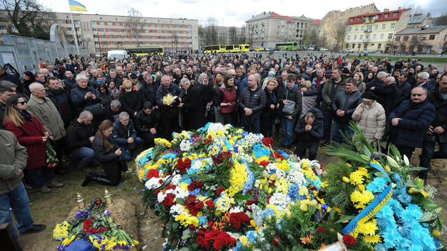 People put flowers on Yuriy Dadak's grave during a funeral 
