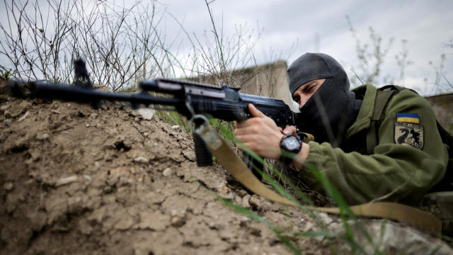 A Ukrainian serviceman points a rifle during tactical exercises at a military camp amid Russia's invasion of Ukraine, in Zaporizhzhia, Ukraine, April 29, 2022. 